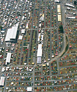 1978 Ford Mustang II - An aerial perspective captures a vast outdoor market filled with numerous vehicles, suggesting a car show or swap meet.