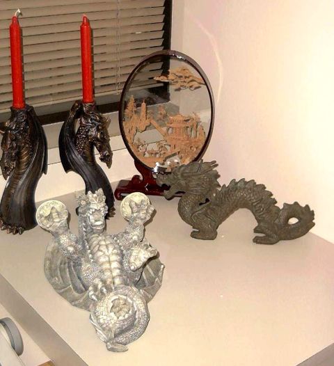 1976 Ford F-150 - Decorative dragon statues and red candles are displayed on a shelf, with a miniature Asian landscape scene in the background.