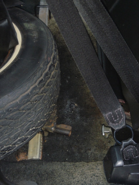 1975 Ford Ranchero - Spare tire and seatbelt visible in the rear of a vehicle.