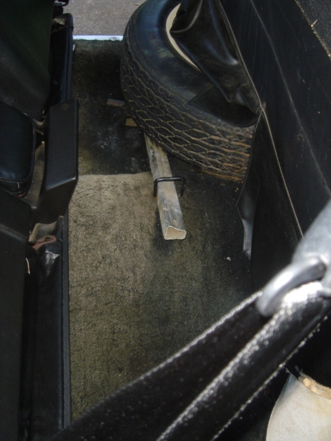 1975 Ford Ranchero - Spare tire and jack are visible in the cargo area of a vehicle.