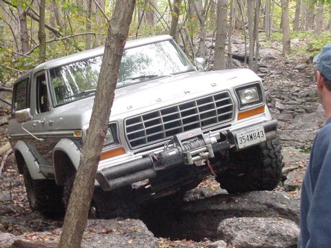 1978 Ford Bronco - This 1978 Ford Bronco is shown tackling a challenging off-road course with large rocks.