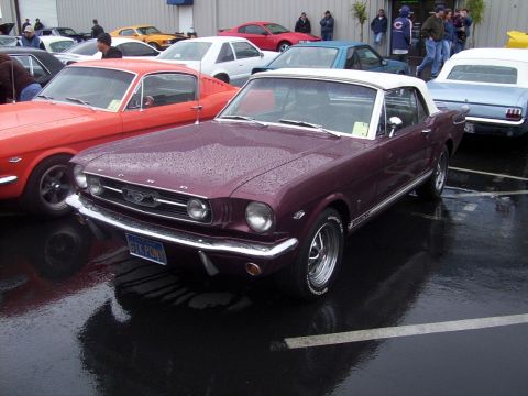 2002 Ford Mustang - A maroon convertible Mustang with a white top is parked in a lot with other vehicles. The license plate reads GTK PONY.