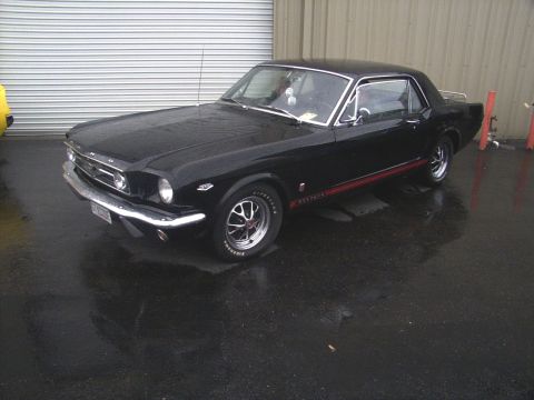 2002 Ford Mustang - This black coupe features a red stripe along its side, indicative of a 1965 Mustang model.