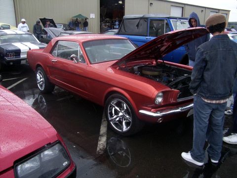 2002 Ford Mustang - A red 1965 Ford Mustang coupe is displayed with its hood open, revealing the engine bay.