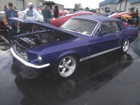 2002 Ford Mustang - A blue 1967 Ford Mustang GT350 is displayed with its hood open at an outdoor event.