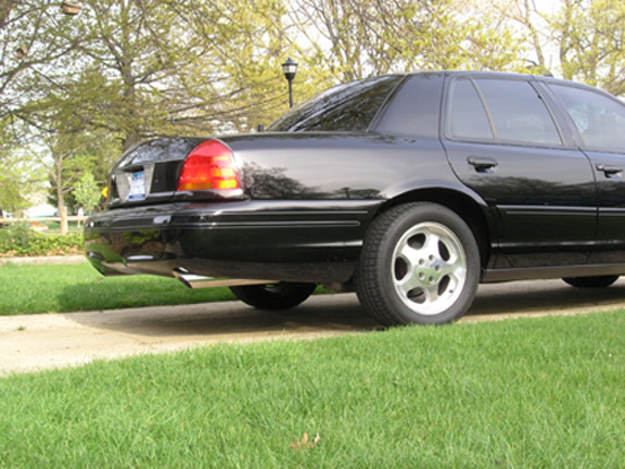 black sedan parked on grass, rear quarter view