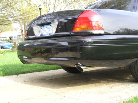 1999 Ford Crown Victoria - A black Ford Crown Victoria is parked on a driveway, with a blue car visible in the background.
