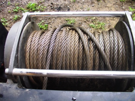 1990 Ford Bronco - Close-up of a winch drum filled with steel cable, ready for use.