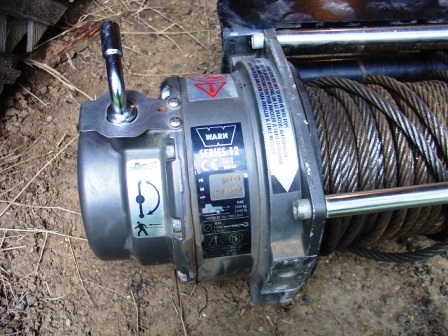1990 Ford Bronco - A Warn Series 12 winch is shown close-up, with its steel cable wound tightly.