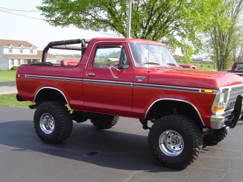 1978 Ford Bronco - This lifted 1978 Ford Bronco is shown from a 3/4 front angle, highlighting its off-road tires and chrome wheels.
