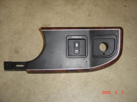 1990 Ford Bronco - This interior trim piece features an overdrive switch and a wood grain accent, likely from a truck or SUV.