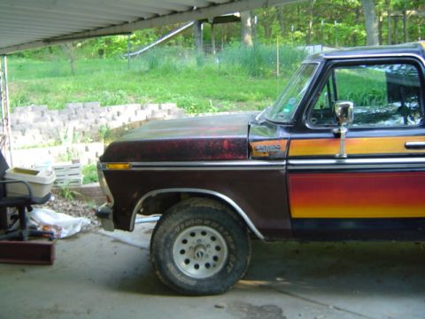 1979 Ford Bronco - This Ford Bronco has a distinctive stripe pattern on its side, with a weathered hood and fender.