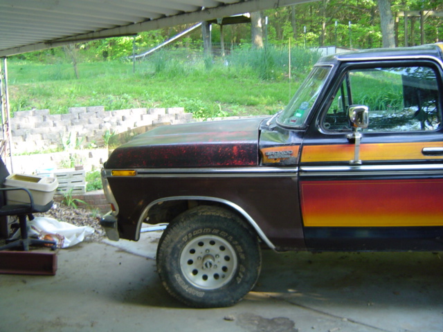 Side view of a brown Ford Bronco with orange and red stripes on the door