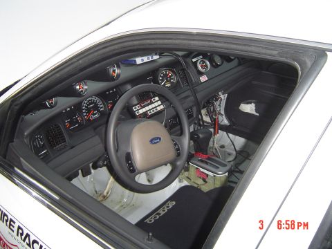 1999 Ford Crown Victoria - The interior of a modified car shows racing modifications and aftermarket gauges.