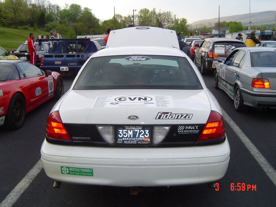 Rear of white 1999 Ford Crown Victoria with hood open, license plate 35M 723