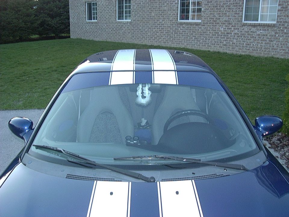 Blue car with white racing stripes on the hood and roof, seen from above the windshield