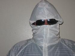 1986 Ford Bronco - A person is covered in a white protective suit, obscuring their face with sunglasses and a hood.