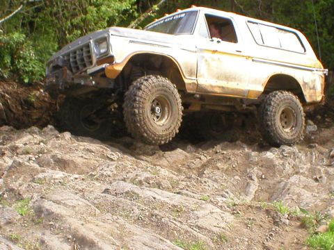 1978 Ford Bronco - This modified SUV navigates a challenging rocky terrain, its off-road capabilities.