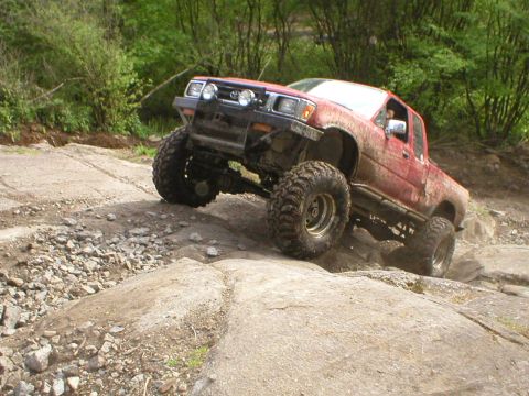 1978 Ford Bronco - Modified Toyota pickup truck navigating a rocky trail during an off-road excursion.