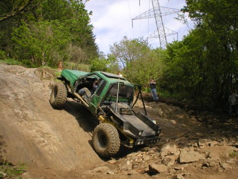 1978 Ford Bronco - A heavily modified off-road vehicle navigates a challenging rocky terrain under a power line tower.