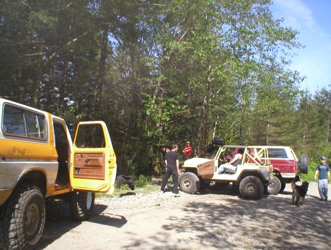1978 Ford Bronco - Several off-road vehicles, including a 1978 Ford Bronco, are gathered in a wooded area.