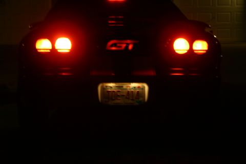 1995 Ford Probe - Rear view of a 1995 Ford Probe GT, showing illuminated brake lights and license plate.