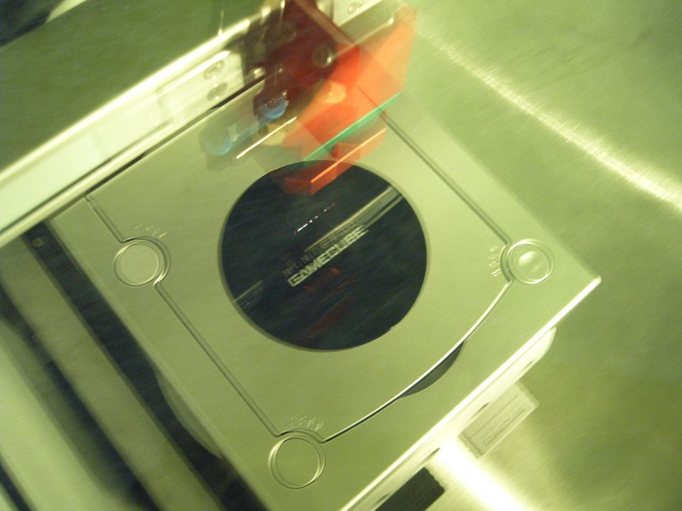 Silver Nintendo GameCube console with red and green accents on top, angled view