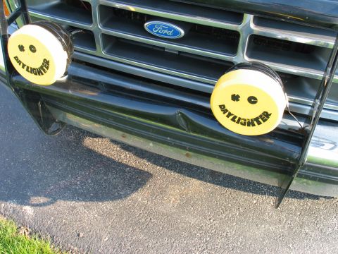 1995 Ford Bronco - Front view of a 1995 Ford Bronco, smiley face Daylighter lights and a dented bumper.