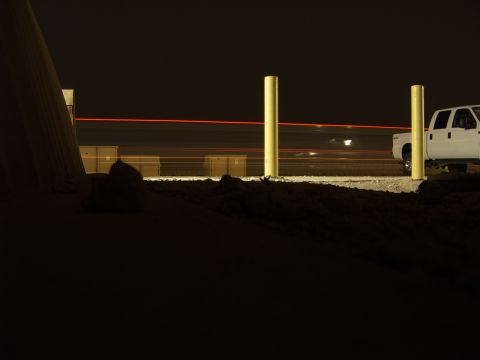 1988 Ford Bronco - A white pickup truck is visible at night with red light trails in the background.