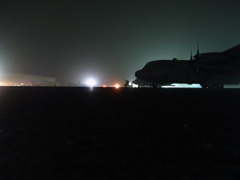 1988 Ford Bronco - An airplane is parked on a tarmac at night, illuminated by distant lights.