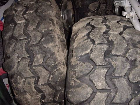 1971 Ford Bronco - Close-up view of two dirty off-road tires, revealing their deep tread patterns.