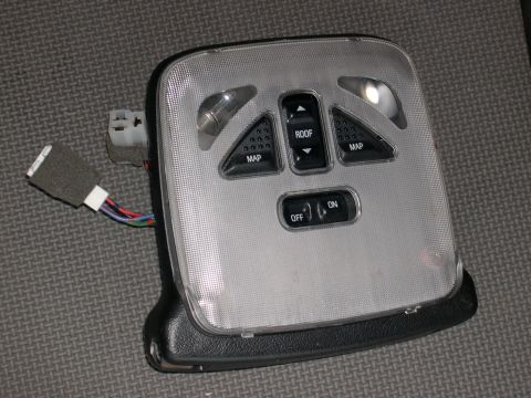 1997 Ford Probe - This is a vehicle's overhead interior light assembly with multiple buttons for map lights and roof light control.