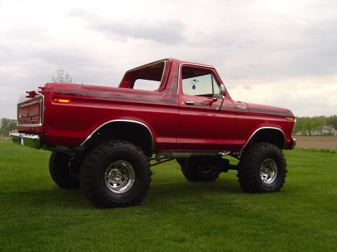 1978 Ford Bronco - This lifted 1978 Ford Bronco is shown from a three-quarter front angle on a grassy field.