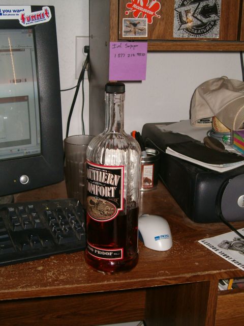 1996 Ford Bronco - A bottle of Southern Comfort sits on a cluttered desk with a computer and various office supplies.