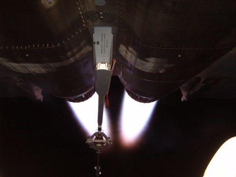 1988 Ford Bronco - The underside of a jet engine shows exhaust flames and an emergency arresting hook label.