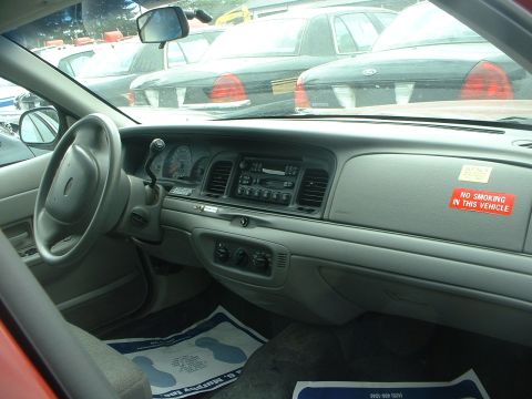 1999 Ford Crown Victoria - Interior of a 1998 Ford Crown Victoria, a "No Smoking" sticker on the dash. Multiple vehicles are parked outside.