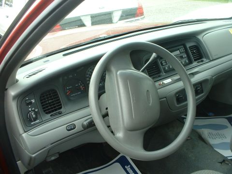 1999 Ford Crown Victoria - The dashboard and steering wheel of a 1999 Ford Crown Victoria are visible.