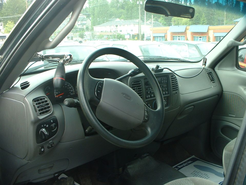Interior of a pickup truck with a gray dashboard and steering wheel