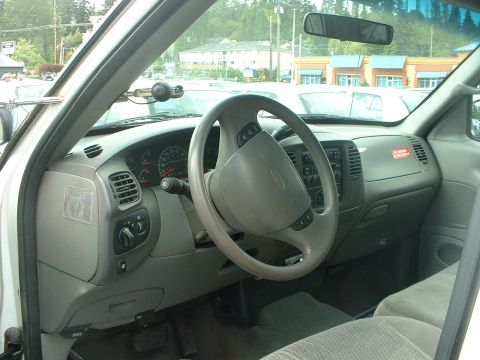 1999 Ford Crown Victoria - The interior of a truck shows a gray dashboard and steering wheel, with a "No Smoking" sticker visible.