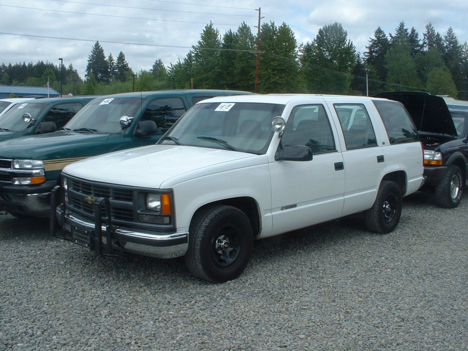 White SUV with push bar parked in gravel lot
