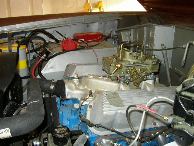 Engine bay showing carburetor, battery, and wiring