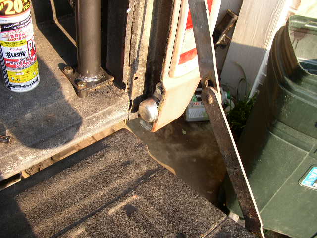 1995 Ford Bronco tailgate interior, showing a can of penetrating oil and a metal bracket
