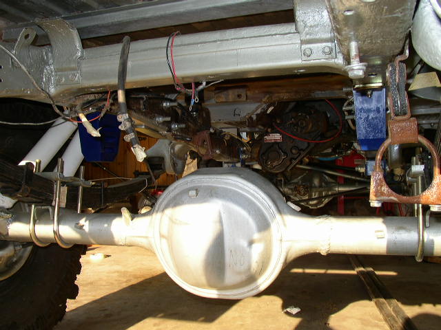 Undercarriage view showing leaf springs, differential housing, and suspension components. Some wiring and mechanical parts are visible