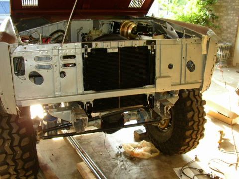 1995 Ford Bronco - The front end of a Ford Bronco is disassembled, revealing the engine, radiator, and suspension components.