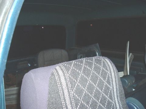 1982 Ford Bronco - The rear interior of a vehicle is shown, with dark tinted windows and patterned seat upholstery.