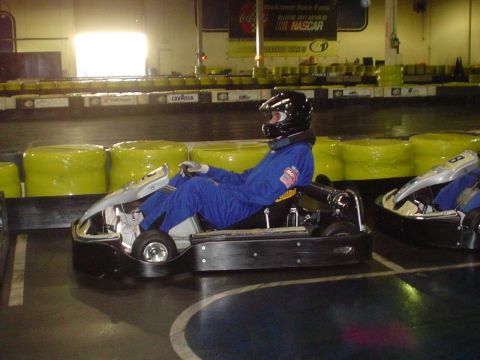 1993 Ford Taurus - Indoor go-kart racing scene with two karts on the track.