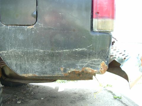 1989 Ford Bronco - The rear quarter panel and bumper show significant rust and damage, indicating poor condition.