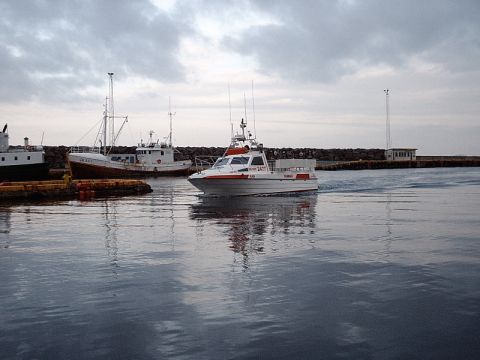 1996 Ford Bronco - Several boats are docked or moving in a harbor under a cloudy sky.