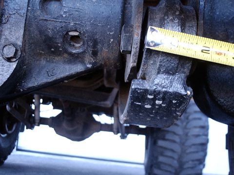 1996 Ford Bronco - A close-up view of a vehicle's suspension component, with a measuring tape indicating a dimension.