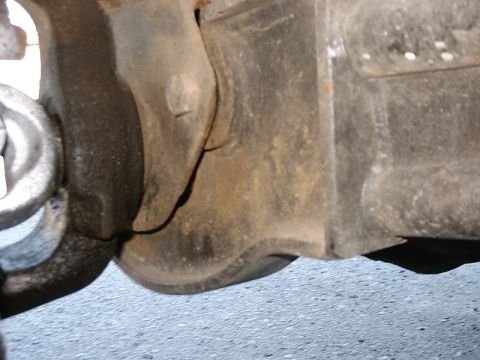 1996 Ford Bronco - A close-up view of a heavily rusted vehicle suspension component, showing wear and tear.